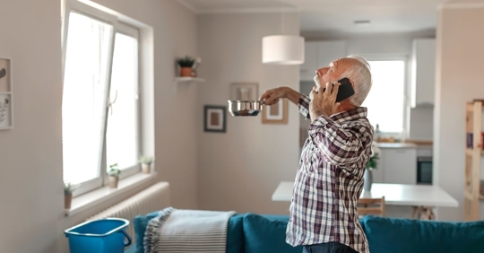 man holding up pan to stop roof leak