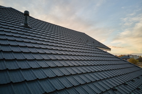 Closeup of house roof top covered with ceramic shingles.